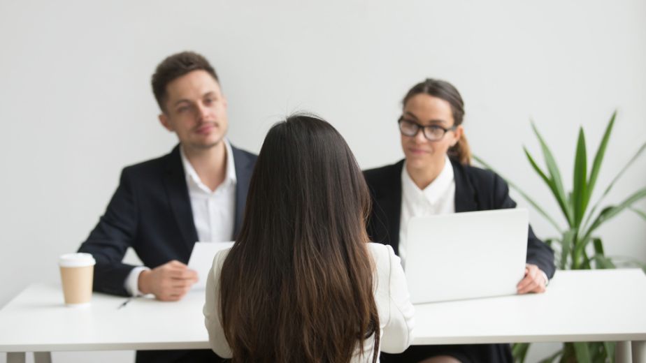 Female candidate getting interviewed by two people, one man and one woman